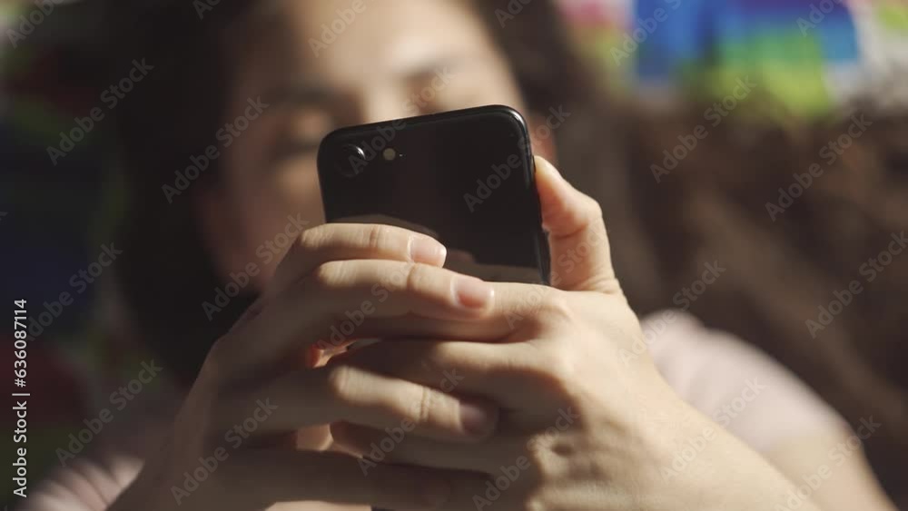 Happy hispanic teen girl holding cell phone using smartphone device at home lying on her bed. Young latin american woman blogger subscribing to new social media, shopping on the internet, ordering. Happy hispanic teen girl holding cell phone using smartphone device at home lying on her bed. Young latin american woman blogger subscribing to new social media, shopping on the internet, ordering.
