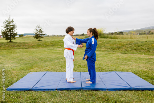 Teenagers practicing judo in park photo