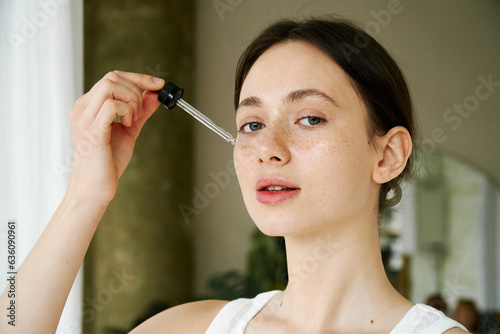 Young Woman Using A Serum Dropper photo