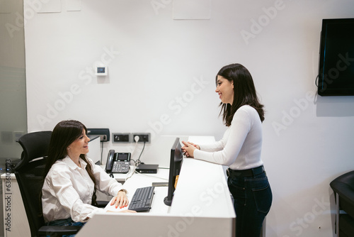 Woman at the reception desk of a dental clinic asking for a quote photo