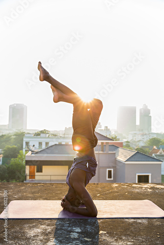 Silhouette of man practicing salamba shirshasana or yoga headstand  photo