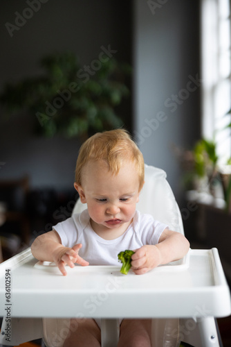 Clean, unsure baby before eating solid food - brocolli. photo