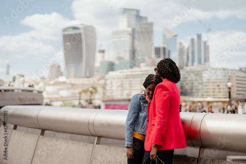 Mother and daughter embracing in the city