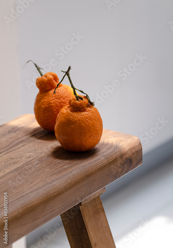 Pair of ugly orange fruit on wooden table