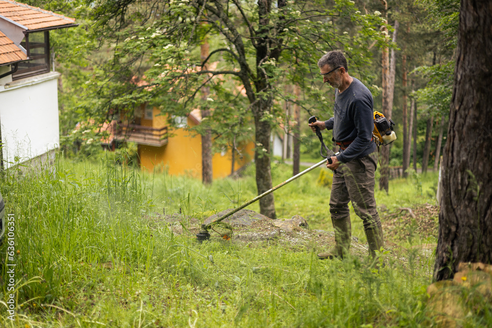 Man mows a mountain yard Man mows a mountain yard