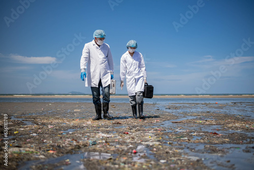 Scientist anaylist wearing protective uniform,mask,glove and box under working water analysis effected from phytoplankton at sea analy case in laboratory is environment pollution problem concept. photo