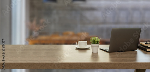 Close up office desk with Computer laptop copy space on table in modern co-working space workplace at business district background interior cafe
