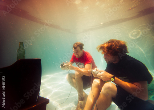 Funny portrait of two friends playing video games in pool photo