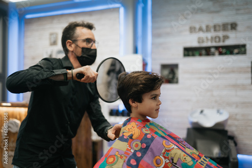 Barber Shows Child's Haircut to Ensure Satisfaction photo