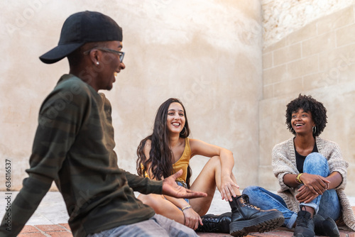 multiracial friends talking sitting outdoors