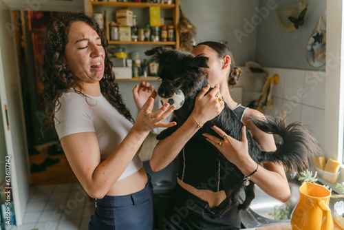 woman holding her dog., friend playing with dog disgusted by saliva 