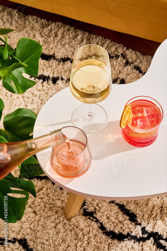 Glass of white wine, rose and cocktail in living room photo