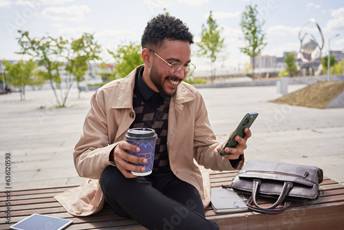 A cheerful businessman reads good news on a smartphone photo