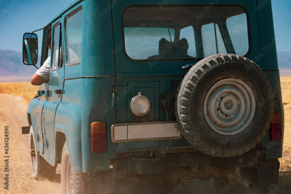 a blue jeep car in a desert land