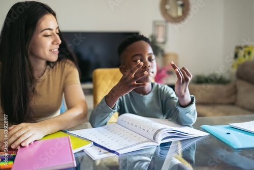 Little boy counting with his fingers while doing his math homework photo