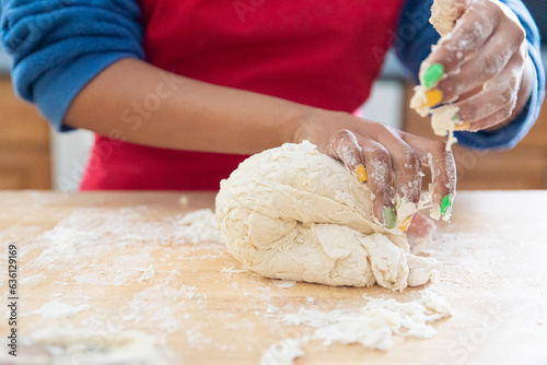 Closeup of a pair of child hands kneading fresh dough.