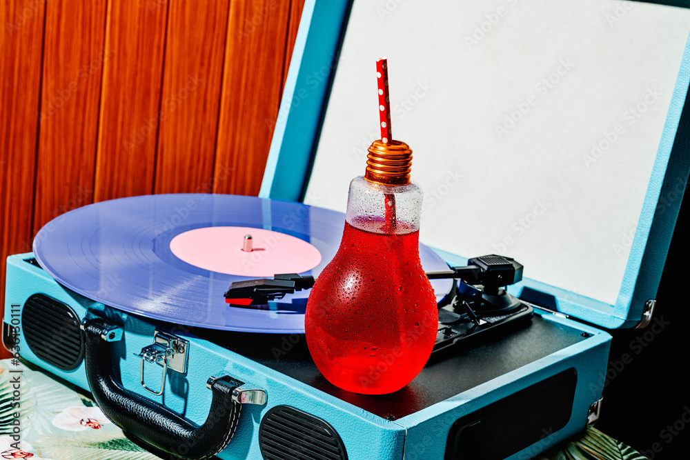 turntable and lightbulb-shaped glass with a red drink