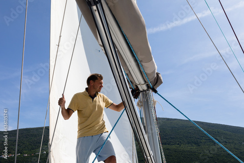 Man among the sails on yacht photo