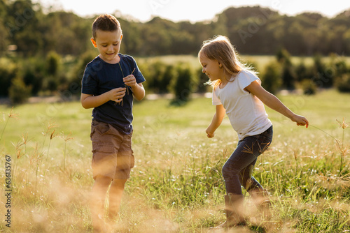 A young boy and girl playing outdoors.