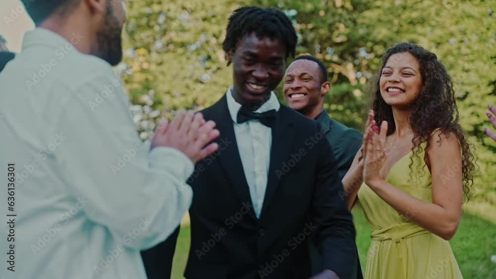 The groom walks past the applauding guests at the outdoor wedding The groom walks past the applauding guests at the outdoor wedding