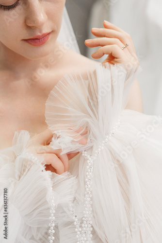 Young elegant bride in wedding dress in room photo