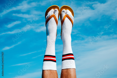 wearing socks and flip-flops upside-down against the sky