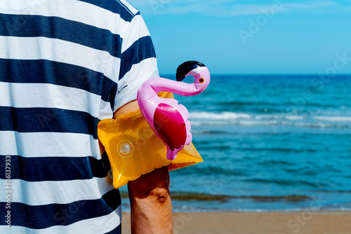 man with a flamingo-shaped armband in his arm