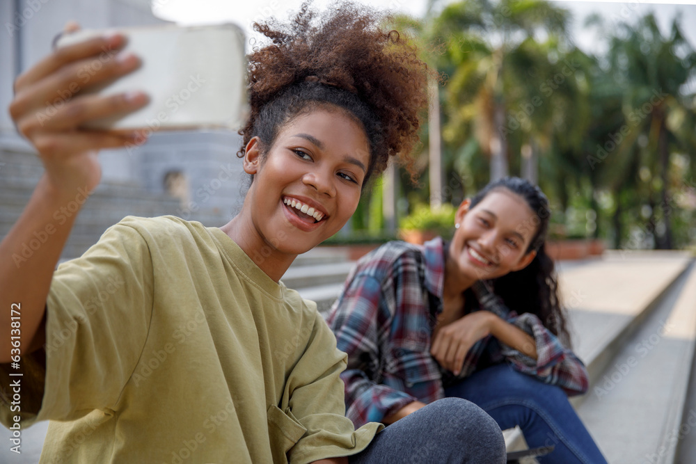 Girl is taking selfie on smart phone with friend on stairs Girl is taking selfie on smart phone with friend on stairs