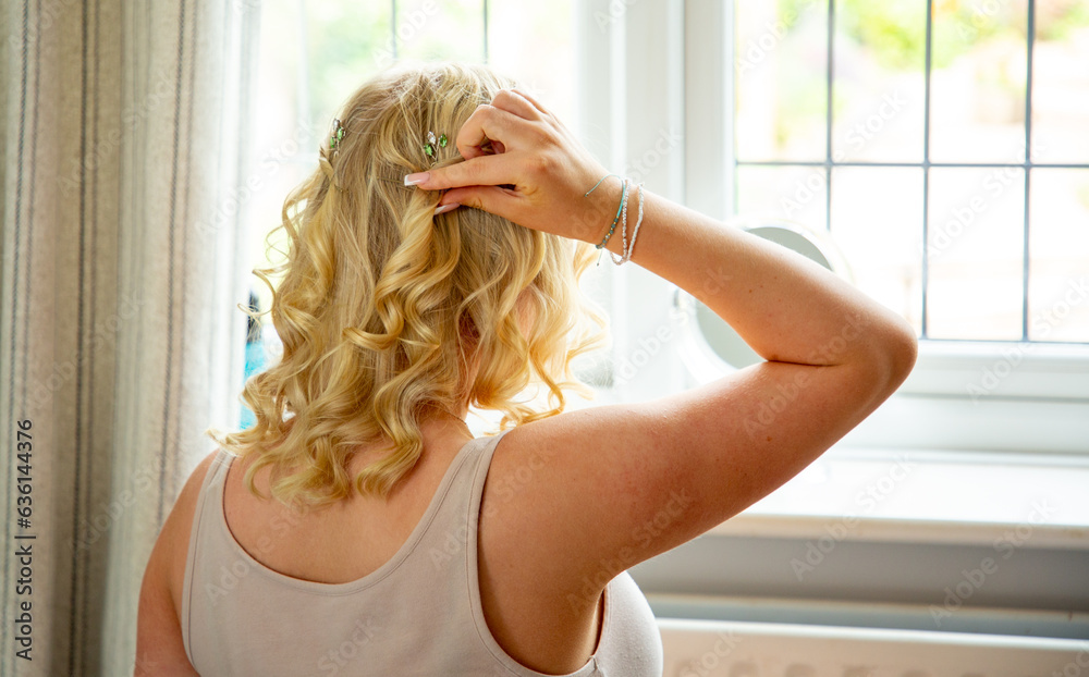 Anonymous blonde teenager doing her hair before prom Anonymous blonde teenager doing her hair before prom