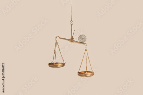 Coin on top of golden empty scales. photo