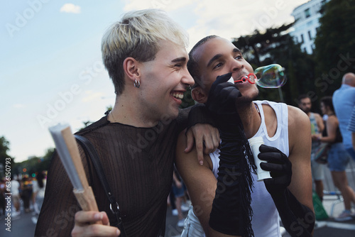 Queer friends hugging and playing with bubbles during pride photo
