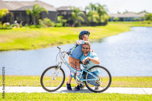 active father setting a example for fathers son. fathers parenting with son outdoor. childhood of son supported by fathers care. father and son on bicycle at fathers day. Dad and kid adventures