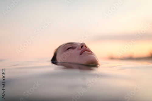 Happy woman floating in daydream summer sea photo