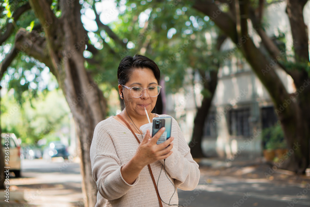 Latina woman on the street drinking a beverage Latina woman on the street drinking a beverage