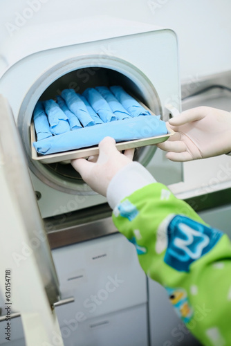 Assistant sterilizing dental instruments