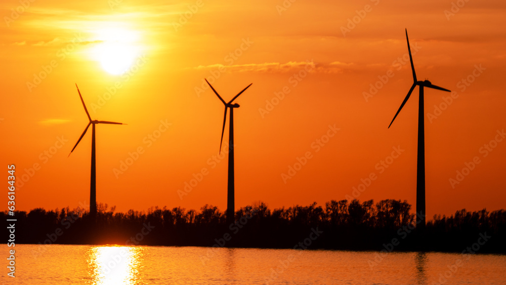 offshore windmill park with clouds at sunset, windmill park in the ocean aerial view with wind turbine Flevoland Netherlands Ijsselmeer. Green energy 