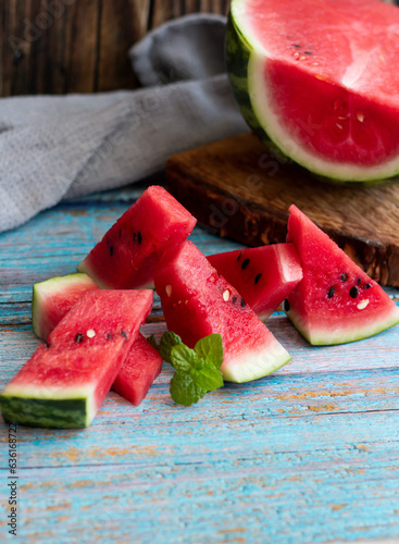 Watermelon slices in a glass on a wooden background. Slices of watermelon on a wooden board. 