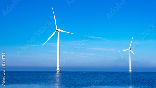 Windmill park with clouds and a blue sky, windmill park in the ocean aerial view with wind turbine Flevoland Netherlands Ijsselmeer. Green energy production in the Netherlands