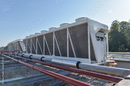 Konstfotografi double stack dry cooler on a roof next to a forest with blue sky - hot or cool f