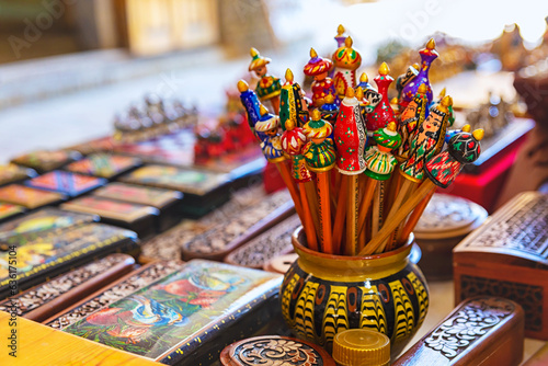 Handmade wooden colorful pencil caps in the form of Uzbek figures. Tourism, souvenir, shoping. Close up, selected focus. Bukhara, Uzbekistan photo