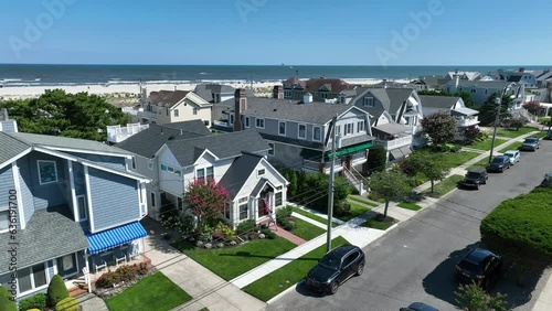 Beach houses with view of ocean. Aerial establishing shot of luxurious homes and rental properties at east coach beach on Atlantic Ocean. Beach town vibe with American flag. photo