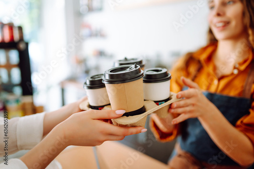 Beautiful barista woman issues coffee orders to go in a coffee shop. Small business owner. Takeaway food and drinks.