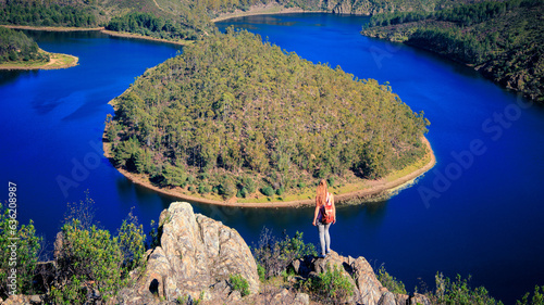 Woman standing on peak enjoying view of meander- Adventure, explore, wanderlust travel concept photo