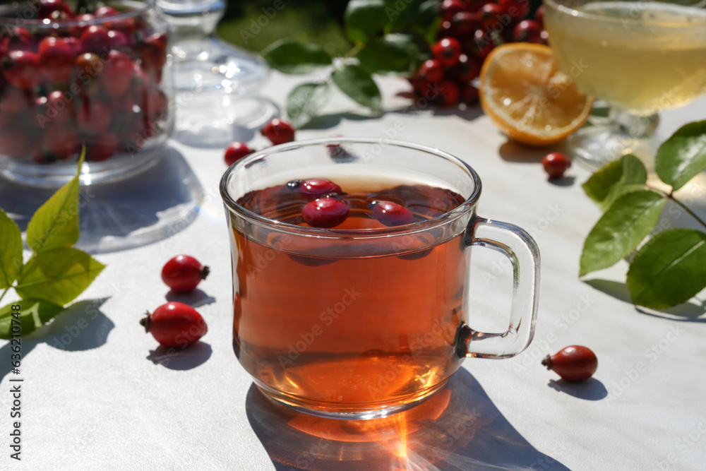 Hot vitamin tea with rose hips with a cup of tea, honey and lemon slices. Phytotherapy. Anti-cold drinks. Side view. Hot vitamin tea with rose hips with a cup of tea, honey and lemon slices. Phytotherapy. Anti-cold drinks. Side view.