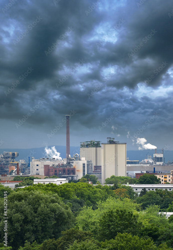 Aerial view of large factory with chimneys emitting smoke into the environment.