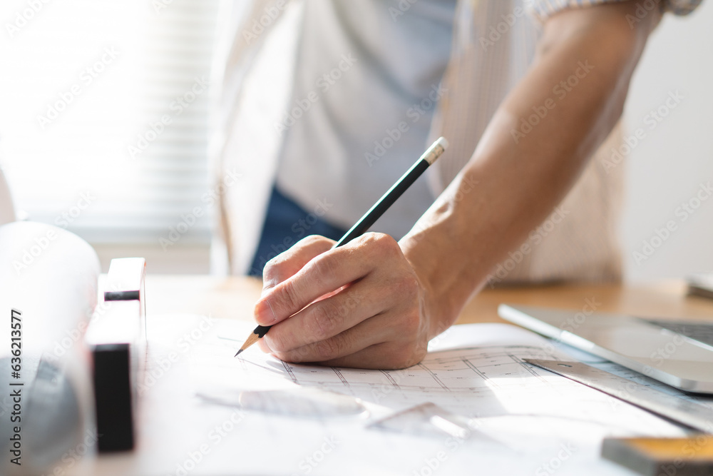 architect work concept. Close up hand of architect writing on the blueprints in the office. architect work concept. Close up hand of architect writing on the blueprints in the office.