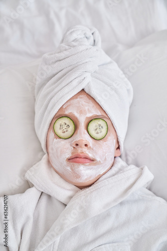 Kid with cucumber mask resting on bed at home