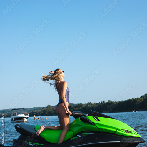 Side portrait of beautiful and sensual woman posing on the beach in summer in bikini on a jet ski 
