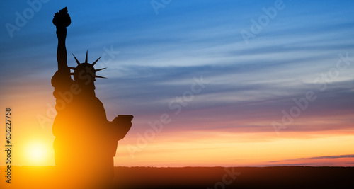 Statue of Liberty on background of sunset sky.