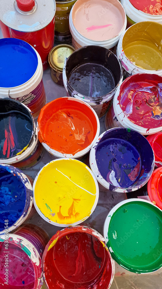 Multicolored open cans of paint on the street. Variety and brightness of the holiday in Spain